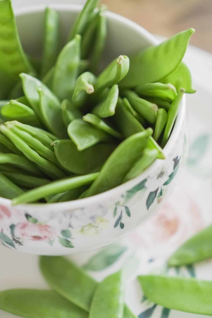 fresh snow peas in a flower print bowl