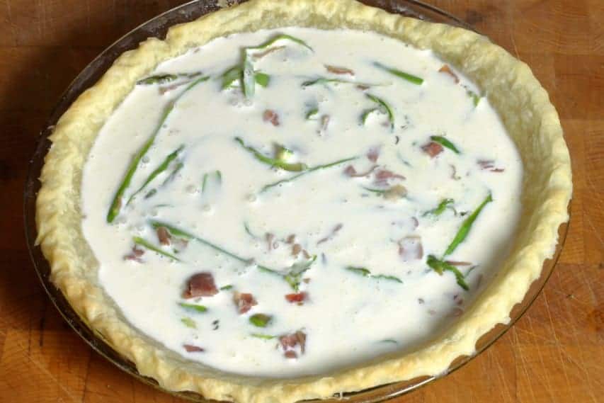 a filled asparagus egg white quiche ready for baking