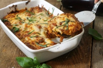 Baked eggplant parmesan being served with a metal spatula