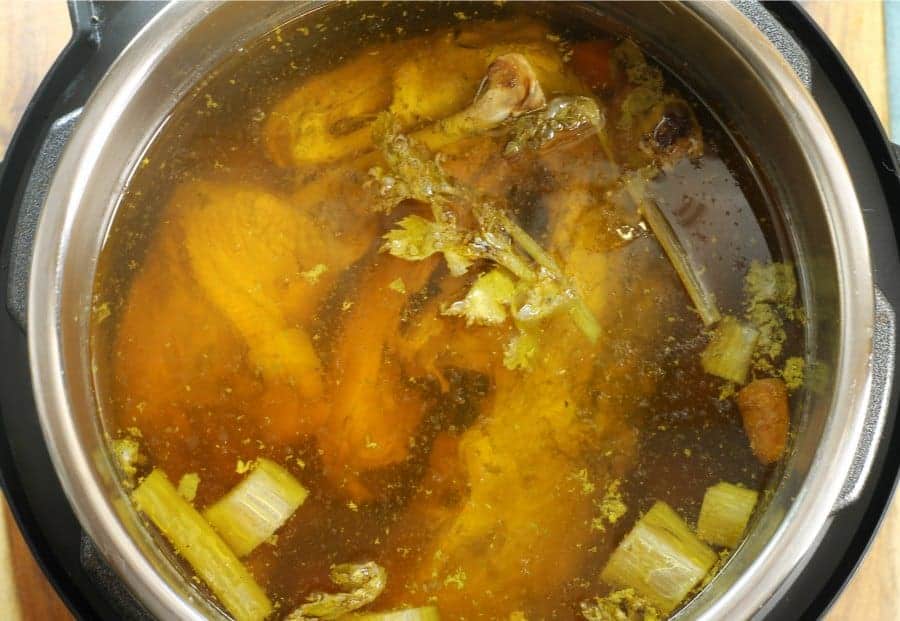 a top down view of an instant pot filled with a finished chicken stock.