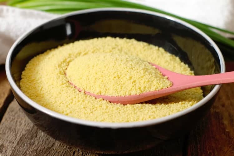 close up image of uncooked couscous in a black bowl