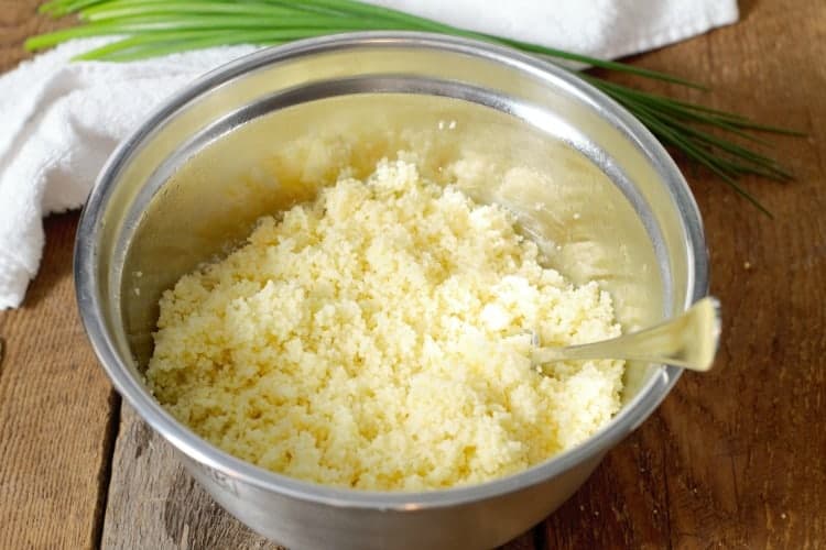 fluffed up couscous in a metal bowl after absorbing hot water