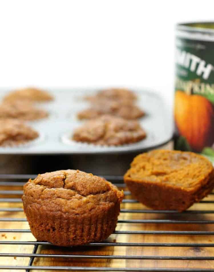 a cut in half pumpkin breakfast muffin on a black wire cooling rack