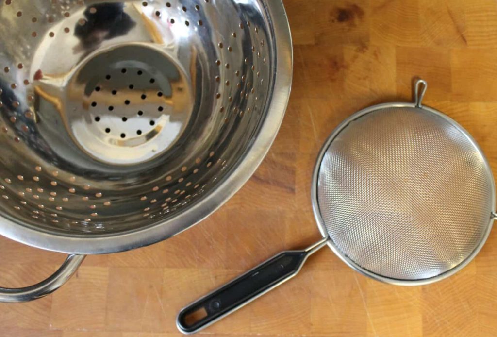 examples of a colander and sieve on a wooden background