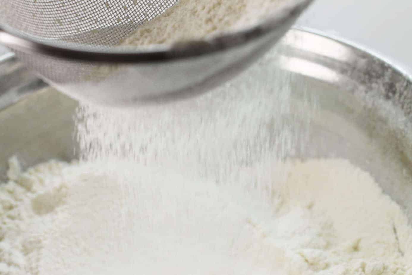 sifting flour for the buttermilk cranberry muffins