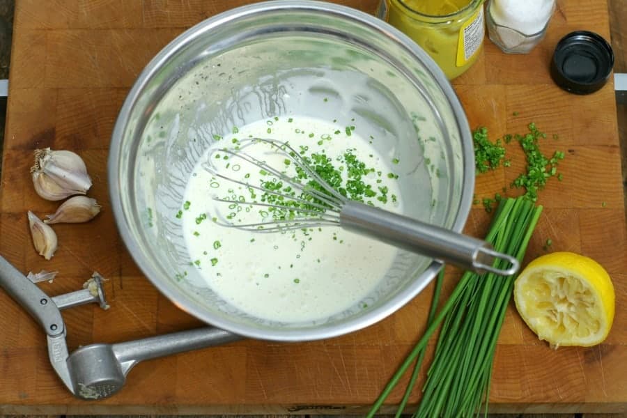 A mixing bowl filled with kale slaw dressing