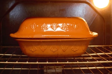 filled clay baker going into a cold oven