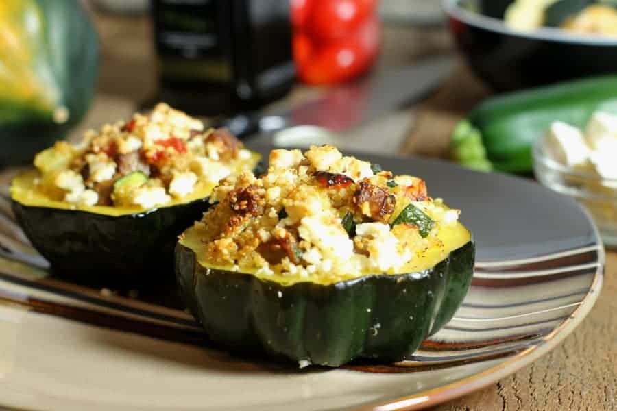 Two acorn squash stuffed with a quinoa and sauasage stuffing baked and topped with cheese