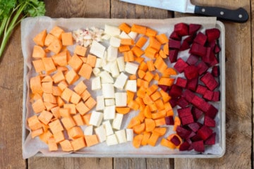 raw root vegetables cut and layed out in a sheet pan