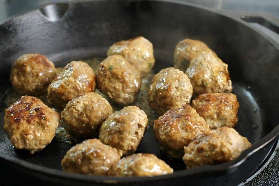 swedish meatballs in a cast iron pan being cooked