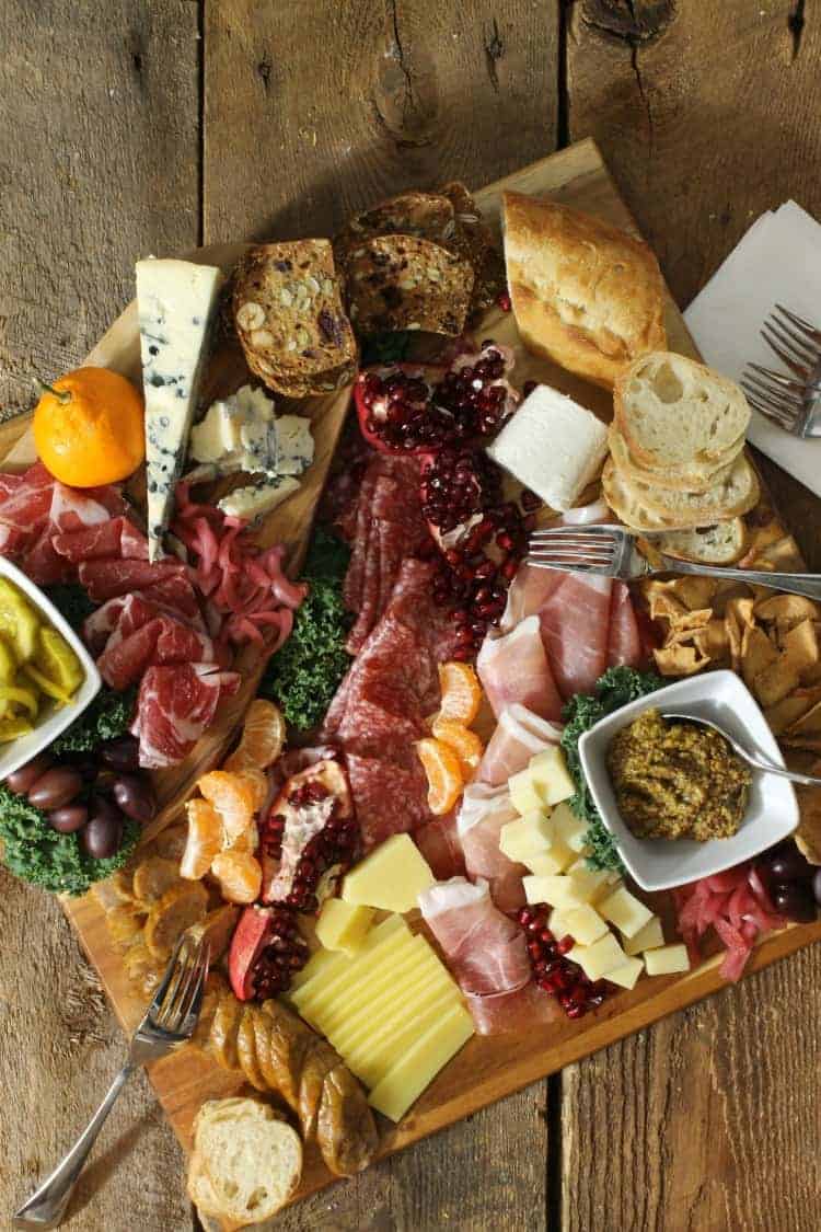 overhead view of a rustic looking charcuterie board platter on a wood board surface